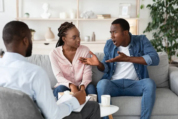 Homem negro ansioso reclamando sobre problemas de relacionamento com a esposa no escritório de conselheiros — Fotografia de Stock