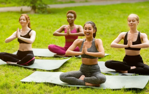 Yoga for peace and harmony. Fit young girls doing meditation or breathing exercises outside — Stock Photo, Image