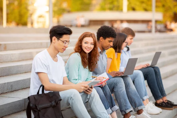 Les étudiants apprennent à se préparer aux examens assis sur les marches du collège en plein air — Photo