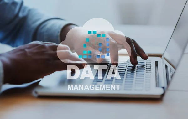 Data Management Konzept. Schwarzer Geschäftsmann arbeitet im Büro am Laptop und analysiert Informationen — Stockfoto