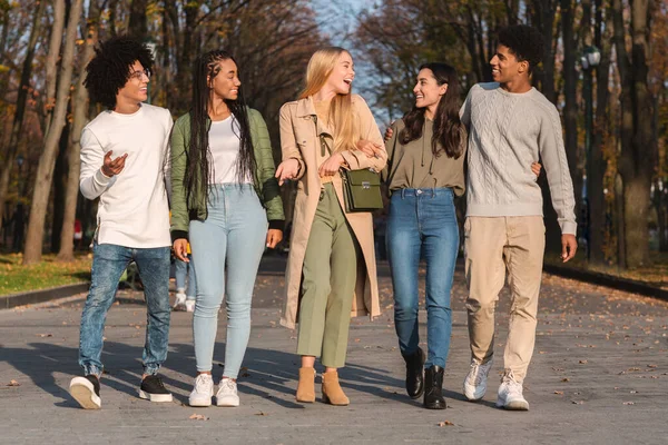 Полноразмерное фото счастливых подростков, гуляющих в парке — стоковое фото