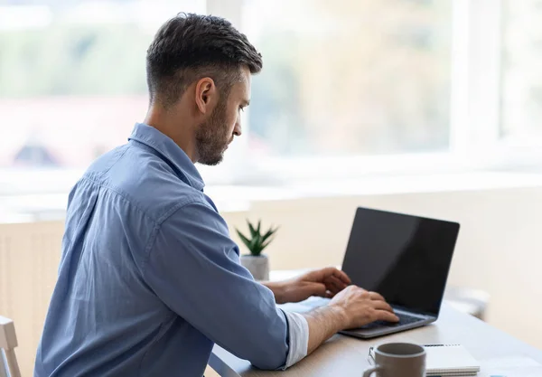Απασχολημένος επιχειρηματίας που εργάζονται σε φορητό υπολογιστή με μαύρη οθόνη στο γραφείο — Φωτογραφία Αρχείου