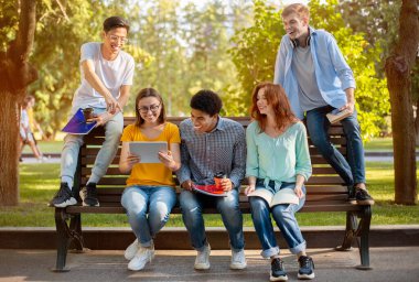 Dışarıdaki bankta oturmuş dinlenen bir grup öğrenci.