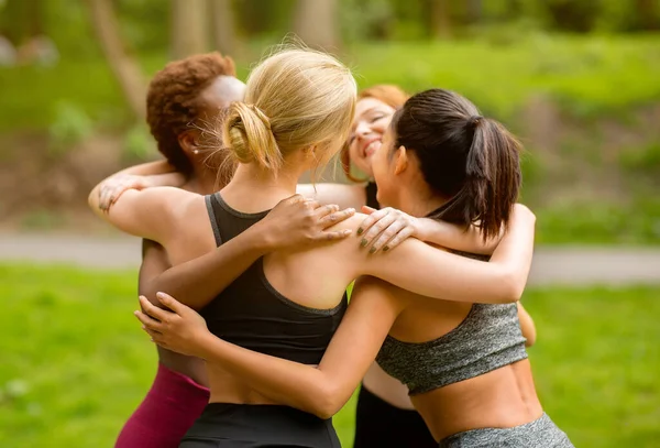 Melhores amigos em roupas esportivas abraçando ao ar livre após a aula de ioga — Fotografia de Stock