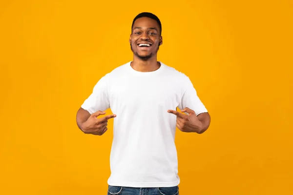 Hombre africano señalándose a sí mismo de pie en el estudio, fondo amarillo — Foto de Stock