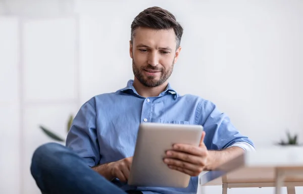 Portret van knappe jonge man met behulp van digitale tablet tijdens de pauze in Office — Stockfoto