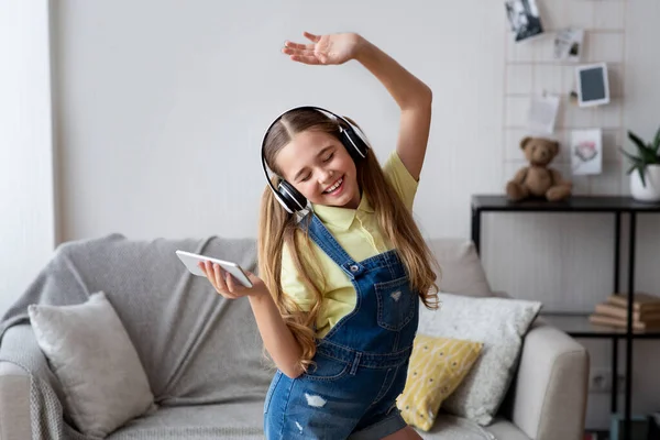 Kinderdansen en haar mobiele telefoon vasthouden — Stockfoto