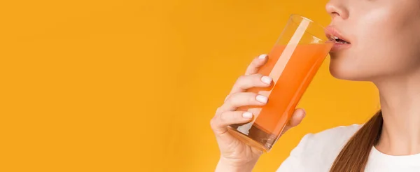 Unerkennbare Frau trinkt Orangen- oder Karottensaft — Stockfoto