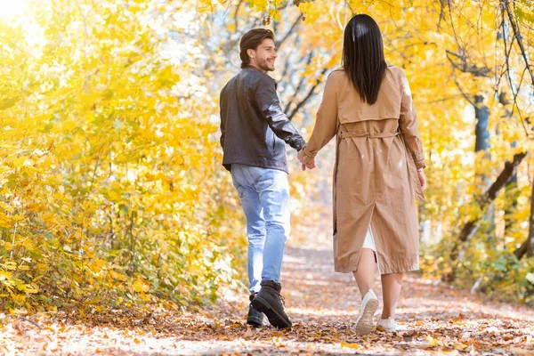 Opgewonden man trekken zijn vriendin terwijl wandelen door bos — Stockfoto