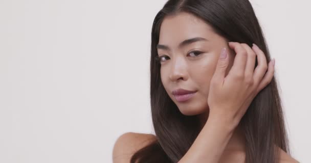 Young beautiful asian girl looking at camera — Stock Video