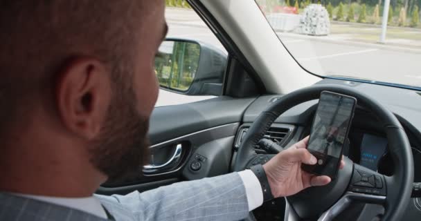Podnikatel dělá selfie na mobilu, sedí v autě na sedadle řidiče — Stock video