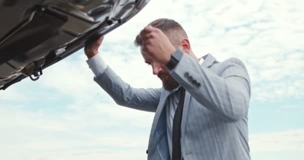 Triste homem de negócios abrindo capuz do carro e olhando para o colapso outdoo — Vídeo de Stock