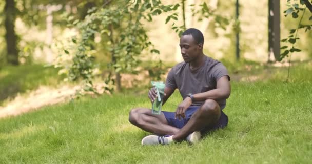 Giovane ragazzo africano americano che beve acqua dalla bottiglia di sport — Video Stock