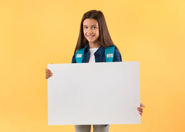 Opgewonden klein meisje met wit papier voor promo — Stockfoto