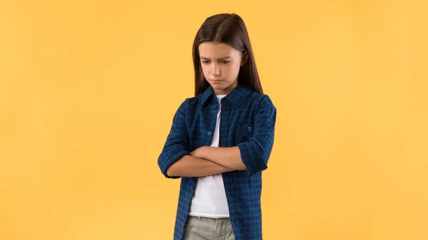 Portrait of sad girl with folded arms standing at studio — Stock Photo, Image