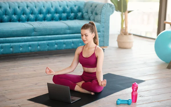 Мирна тисячолітня леді медитує або робить вправи для дихання онлайн-підручник на ноутбуці вдома — стокове фото