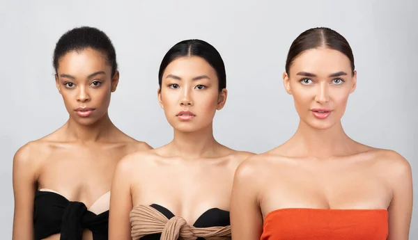 Tre multikulturella modell flickor Posing bär underkläder över grå bakgrund — Stockfoto