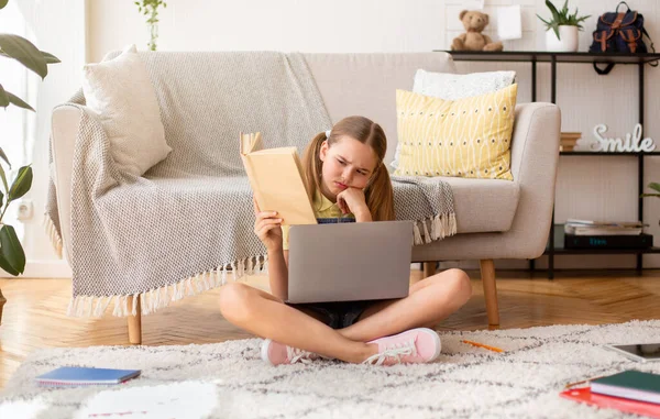 Chica sentada en la alfombra del piso usando el libro de lectura portátil — Foto de Stock