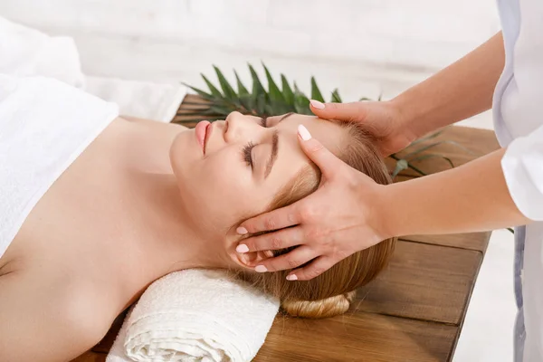 Tratamentos de beleza. Profissional fazendo massagem facial para menina na mesa — Fotografia de Stock