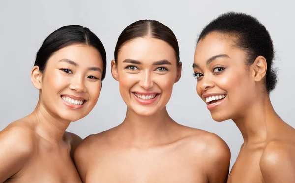 Três modelos diversos meninas sorrindo posando sem camisa em fundo cinza — Fotografia de Stock