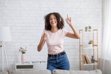 Rahatlama zamanı. Kulaklıklı yakışıklı genç bayan şarkı söylüyor ve dans ediyor.