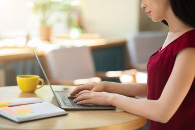 Çevrimiçi Yazışmalar. Kafede dizüstü bilgisayar kullanan Asyalı kadın, iş e-postalarına cevap veriyor.