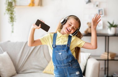 Dans eden ve cep telefonunu tutan kız.