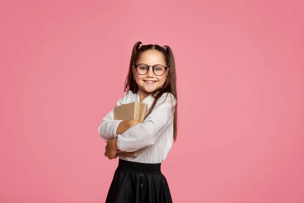 Adoro a escola. Menina sorridente com óculos abraça livros e olha para a câmera — Fotografia de Stock