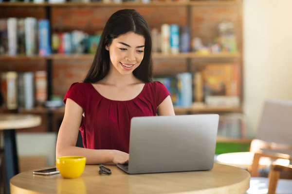 Mulher asiática bonita trabalhando no café com computador portátil — Fotografia de Stock