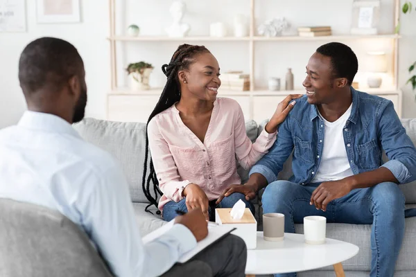 Esposos negros felizes reconciliando depois de terapia familiar bem sucedida no escritório de conselheiros — Fotografia de Stock