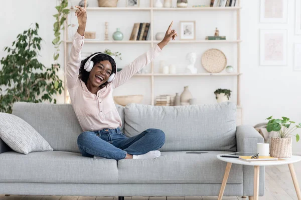 Musica divertente. Emozionato ragazza ascolto canzoni preferite in cuffie wireless a casa — Foto Stock