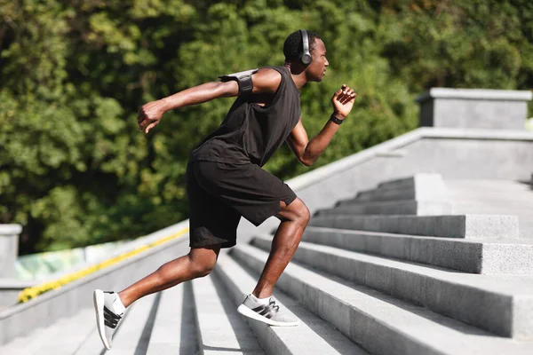 Aktivní životní styl. Sportovní černošky muž běžec na schodech v městském parku — Stock fotografie