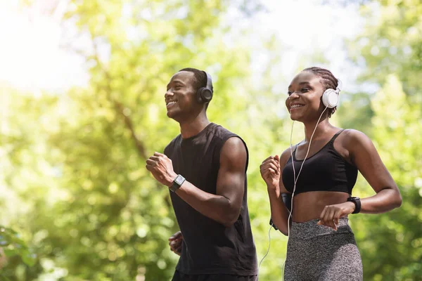 Viel Spaß beim Laufen. Fröhliches afroamerikanisches Paar joggt im Sommerpark — Stockfoto