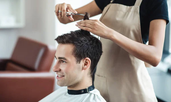 Close up de jovem recebendo corte de cabelo no salão de beleza — Fotografia de Stock