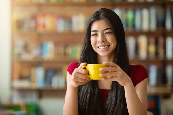 Theetijd. glimlachen aziatisch meisje met mok van warm drinken in cafe — Stockfoto