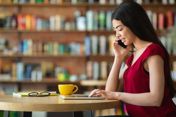 Asiatische Unternehmerin telefoniert im Café und nutzt digitales Tablet — Stockfoto