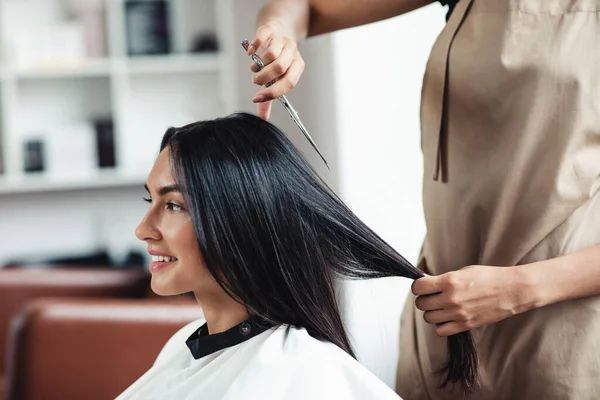 Jovem morena mulher chegando curto corte de cabelo no cabeleireiro, close-up — Fotografia de Stock