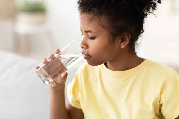 Black Kid Girl Drinking Water Sitting On Sofa At Home — Stock Photo, Image