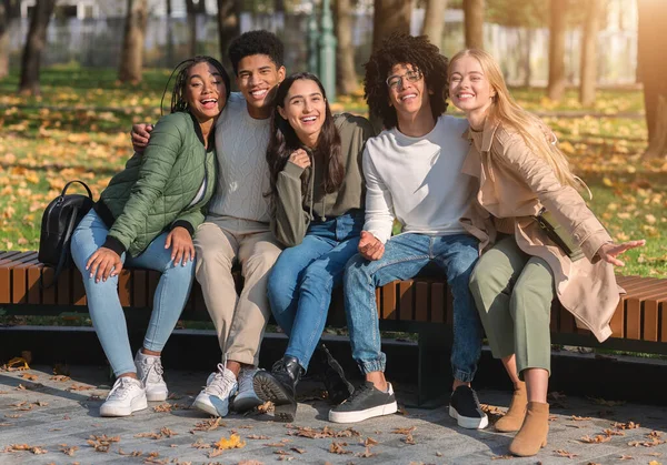 Cheerful friends posing in park while having rest in park — Stock Photo, Image