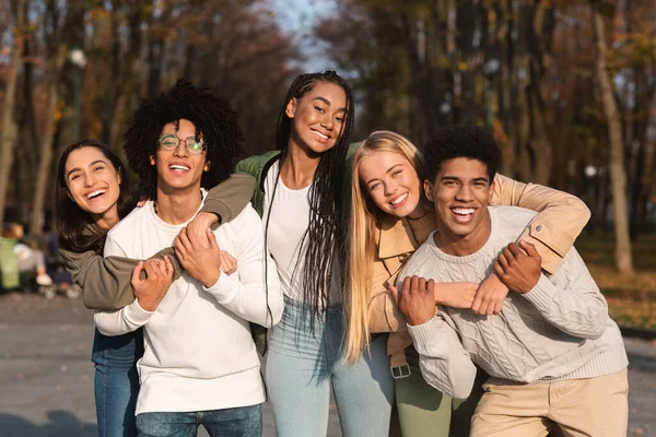 Grupo positivo de jovens amigos se divertindo no parque público — Fotografia de Stock