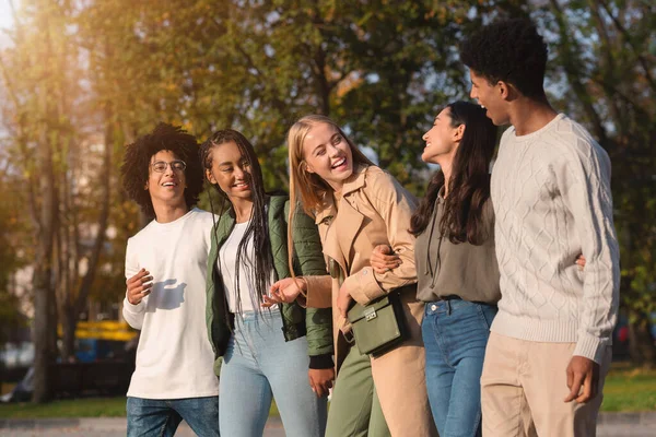 Internationale groep tieners lacht tijdens een wandeling door het park — Stockfoto