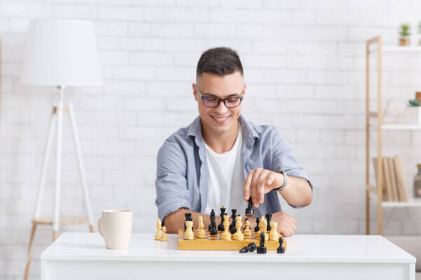 Virtual opponent in chess game. Smiling guy playing board game at online call