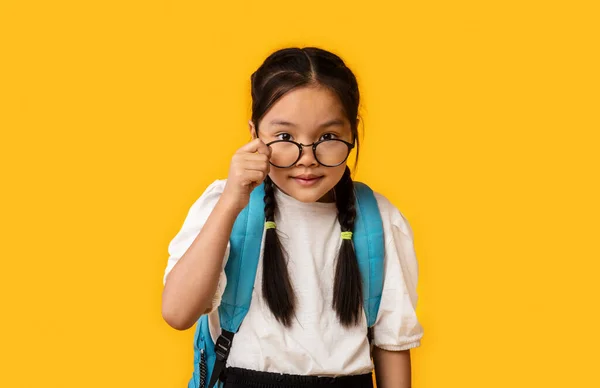 Curioso asiatico studentessa looking a camera sopra occhiali in studio — Foto Stock