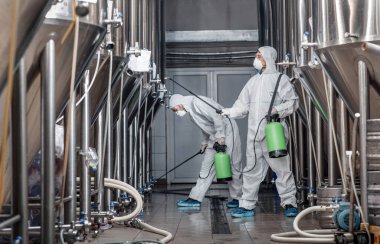 Craft brewery, eco product and disinfection. Workers in hazmat suits clean plant clipart