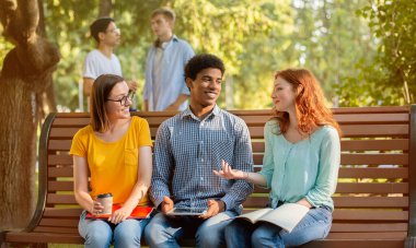 Dersten sonra çeşitli öğrenciler bankta oturup konuşuyor.