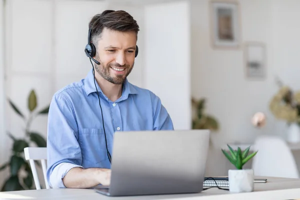 Telefonist aan het werk. Mannelijke manager draagt headset en het gebruik van laptop — Stockfoto