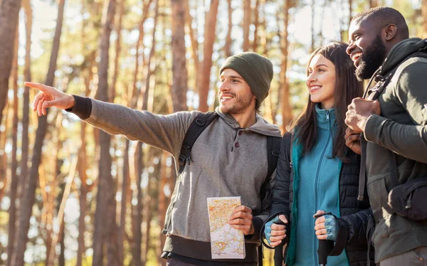 Happy hikers found right way, holding map at forest — Stock fotografie