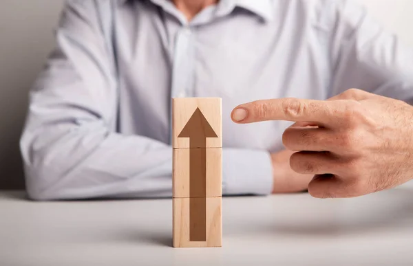 Onherkenbare man wijst naar houten blokken met pijl omhoog — Stockfoto