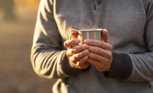 Manos masculinas sosteniendo una taza de té o café caliente — Foto de Stock