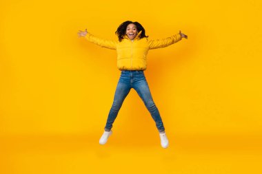 Neşeli Afrikalı Kız Sarı Arkaplanda Yayılmış Kartal Atlaması Yapıyor